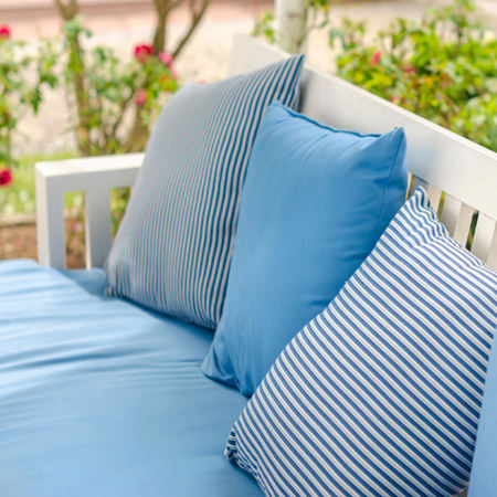 three blue outside cushions on a bench